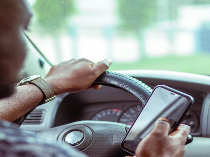 Nairobi driver checking Rada on their phone while at the wheel